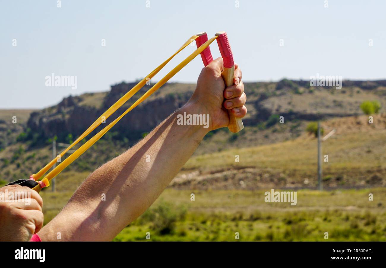 Ein Mann mit Speerwerfer, der Naturunterhaltung mit Steinen wirft Stockfoto