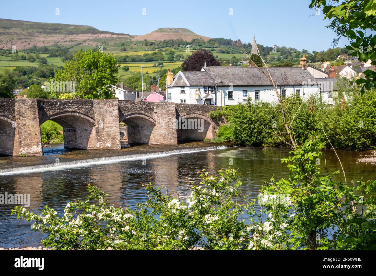 Der Fluss Usk fließt unter der alten Crickhowell Bridge in der südwalisischen Stadt Crickhowell Powys, mit Tafelberg über der Stadt Stockfoto