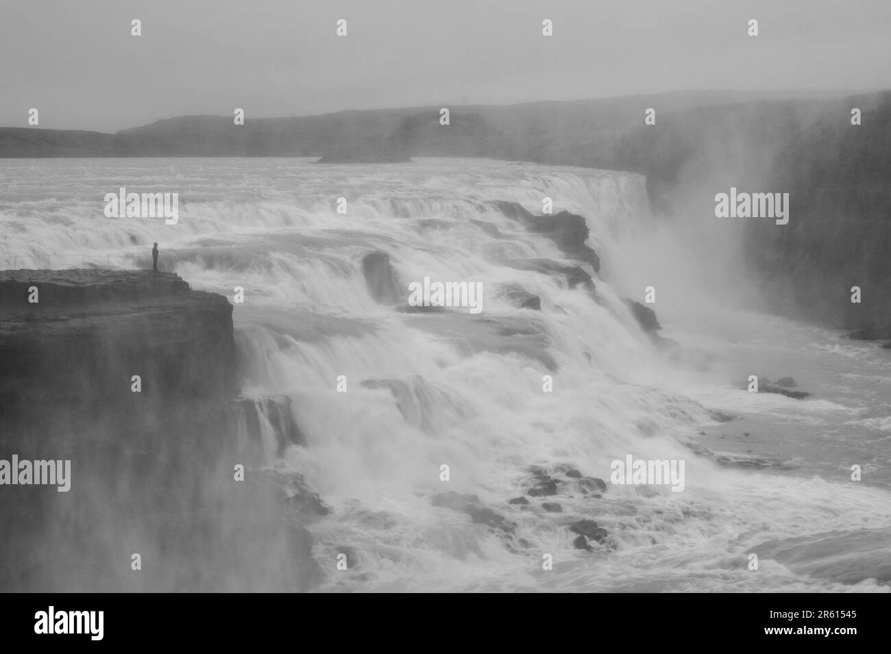 Eine ruhige Landschaft mit einem Wasserfall, der in einen ruhigen See in Island fällt Stockfoto