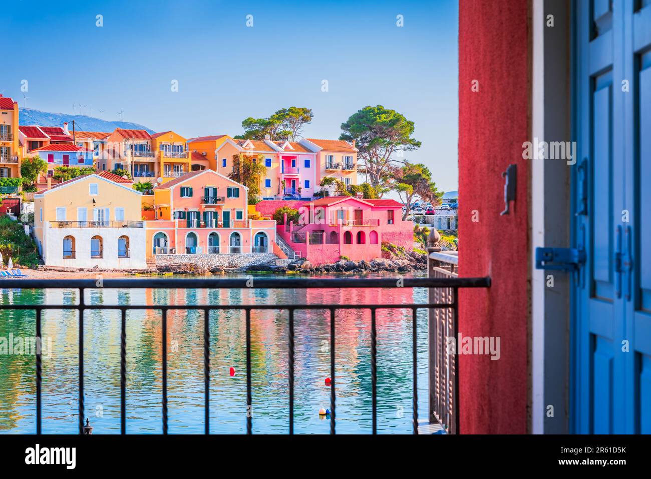 Assos, Griechenland. Malerisches Dorf auf den idyllischen Inseln Kefalonia. Wunderschöne farbenfrohe Häuser und türkisfarbene Bucht. Stockfoto