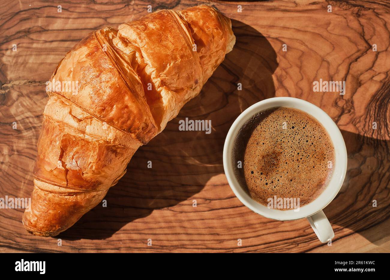 Kaffee und Croissants auf einem Holztisch, französisches Frühstück, sonniger, heller Tag. Flache Ansicht von oben mit Platz für Text Stockfoto