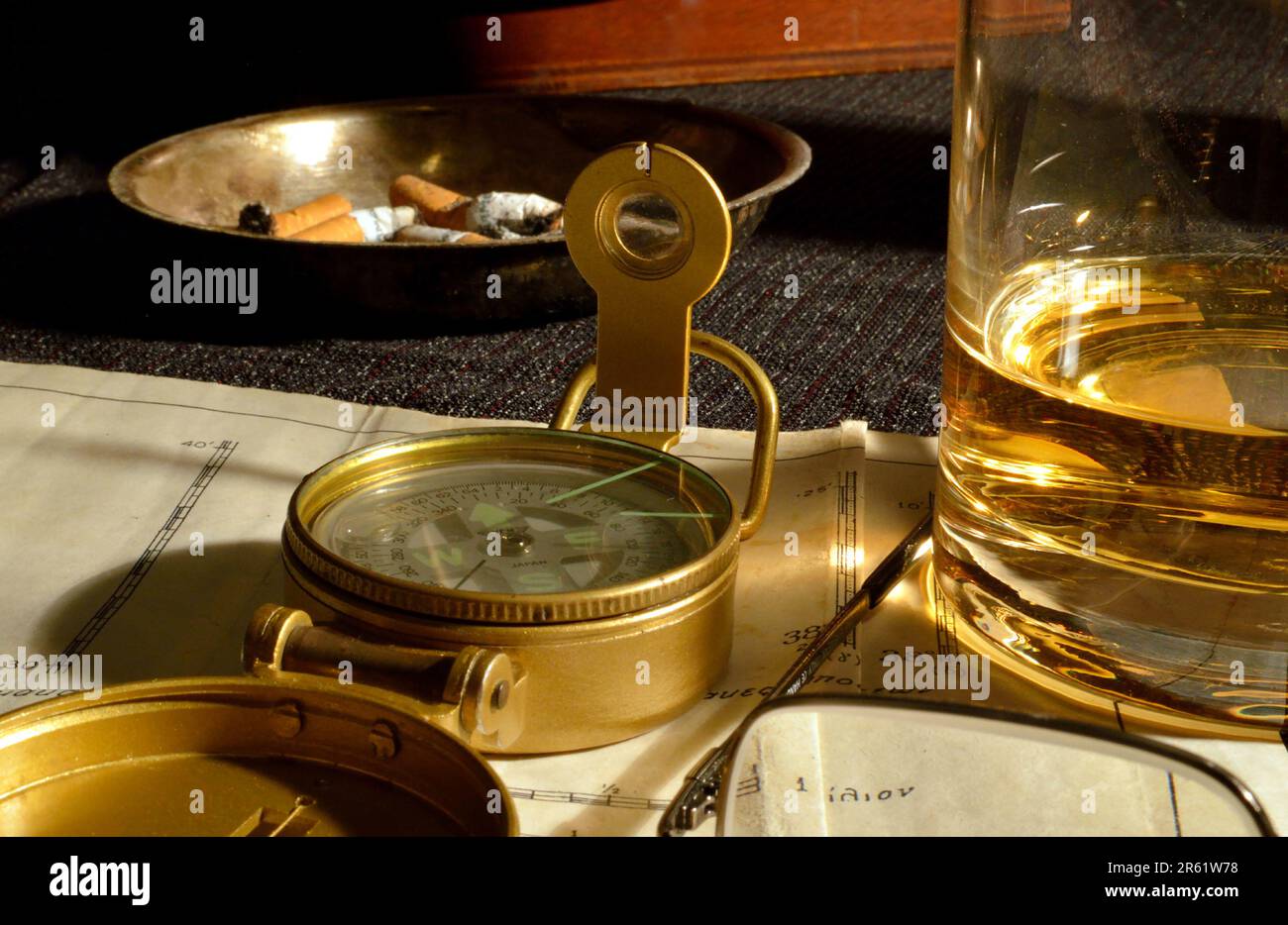 Ein antiker goldener Kompass, der auf einer detaillierten topografischen Karte ruht Stockfoto