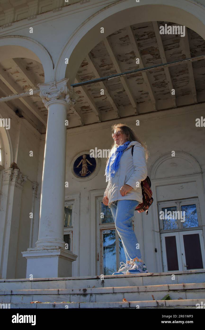 Das Foto wurde in der Stadt Odessa in der Ukraine aufgenommen. Eine junge Touristin auf der Treppe eines alten Anwesens am French Boulevard im ehemaligen D. Stockfoto