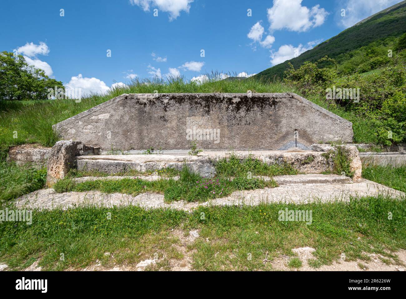 Alter Steinwassertrog zur Trinkwasserversorgung im Sibillini-Nationalpark, Umbrien, Italien, Europa. Inscription vietato sporcare l'acqua gettare rifiuti Stockfoto