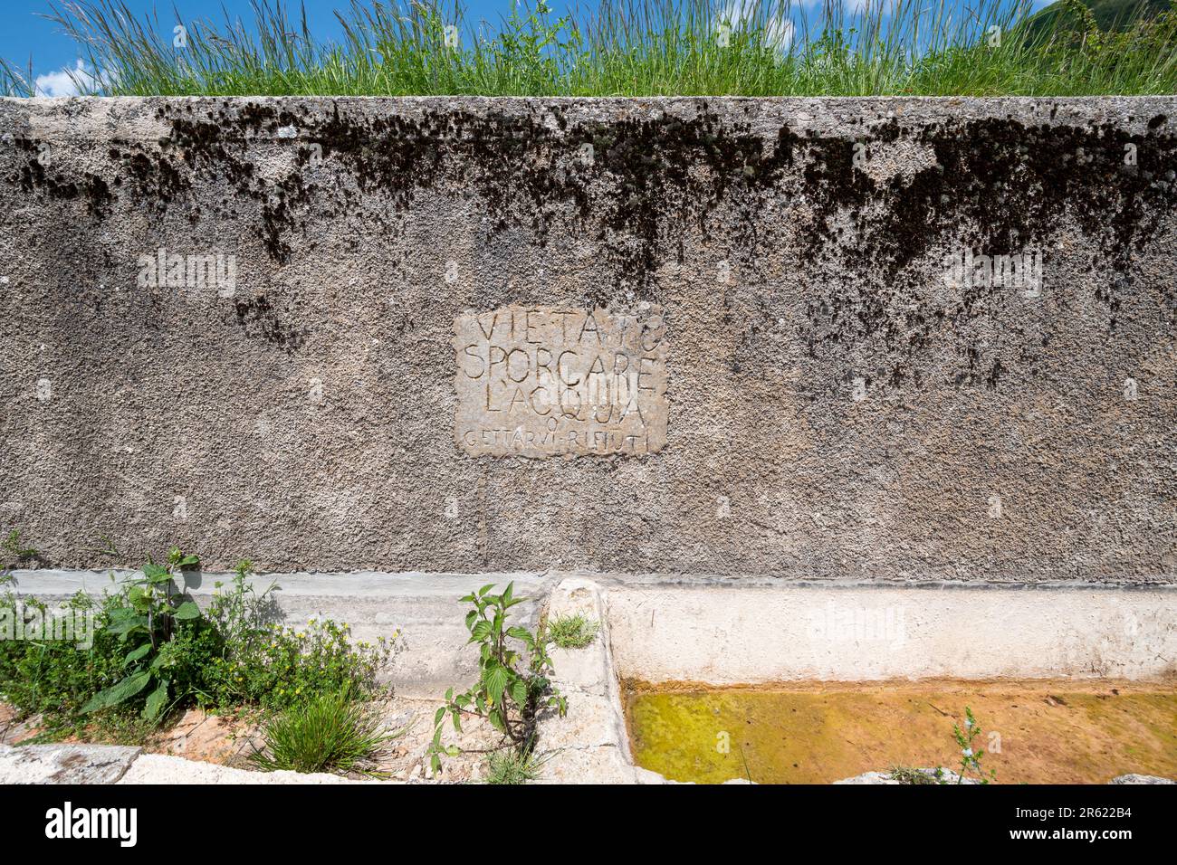 Alter Steinwassertrog zur Trinkwasserversorgung im Sibillini-Nationalpark, Umbrien, Italien, Europa. Inscription vietato sporcare l'acqua gettare rifiuti Stockfoto