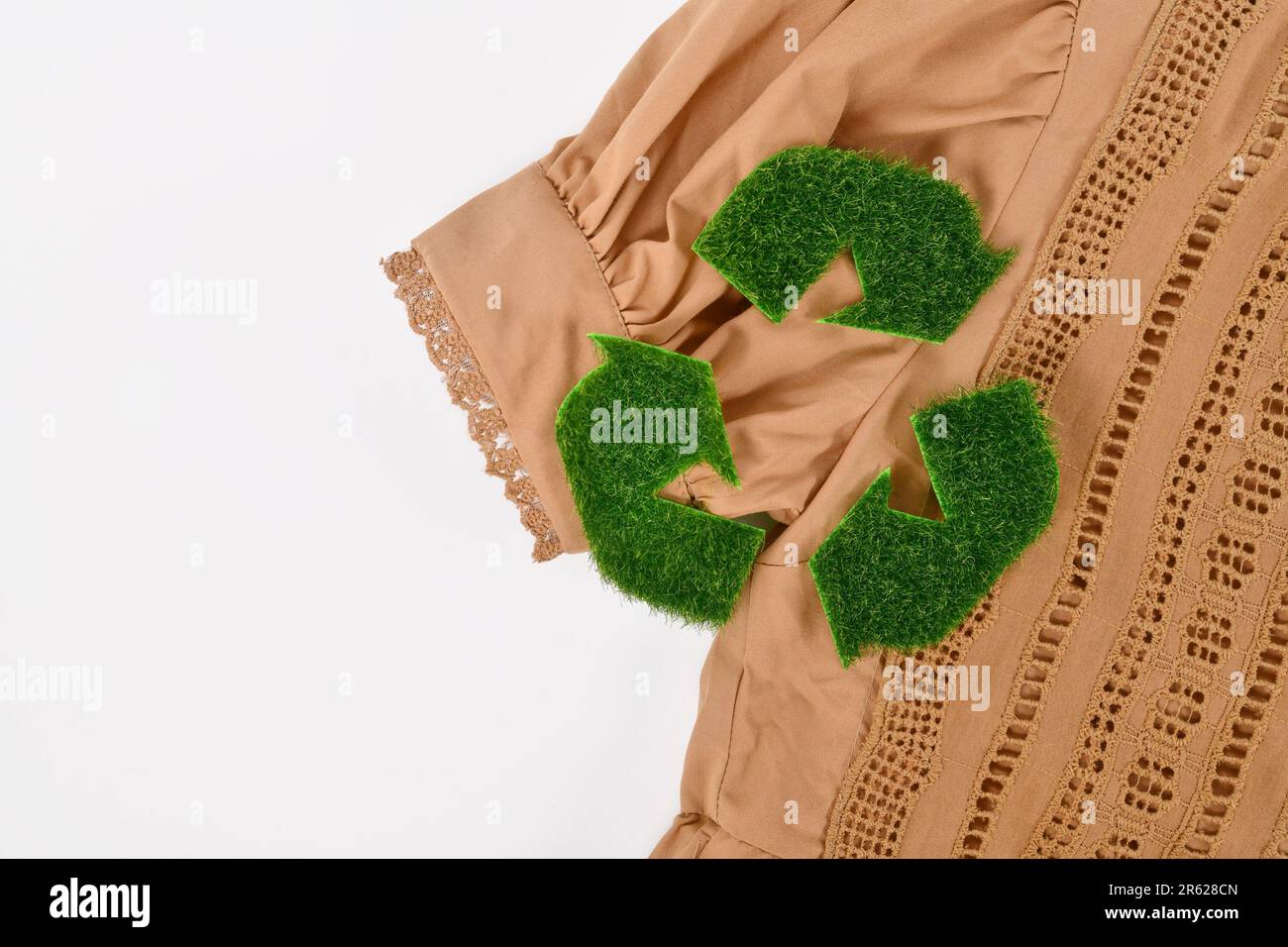 Umweltfreundliche hergestellte Kleidung mit Recycling-Pfeil-Symbol aus Gras Stockfoto