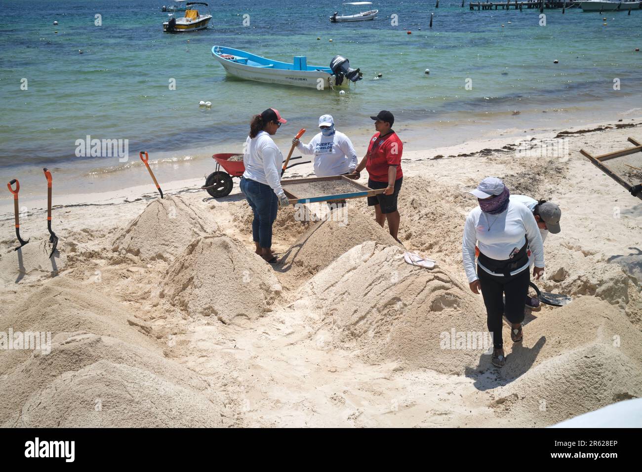 Blue Flag Arbeiter reinigen den Strand Sand in Puerto Morelos Yucatan Mexiko Stockfoto