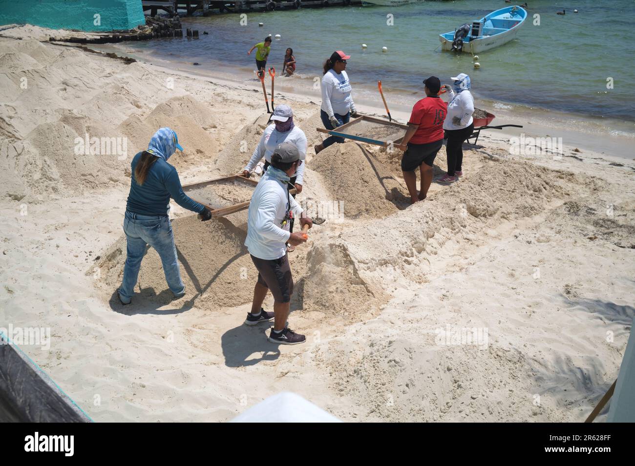 Blue Flag Arbeiter reinigen den Strand Sand in Puerto Morelos Yucatan Mexiko Stockfoto