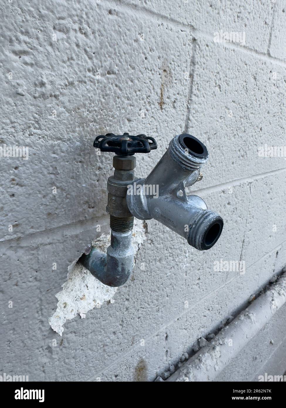 Eine detaillierte Nahaufnahme eines Metallrohrs, das an einer Wand befestigt ist, erfasst die Textur Stockfoto