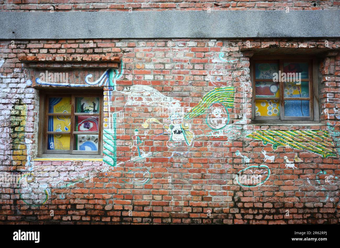 Dieses Stockfoto zeigt ein pulsierendes Stadtbild mit einem modernen Gebäude, geschmückt mit farbenfroher Kunst auf der Außenseite Stockfoto