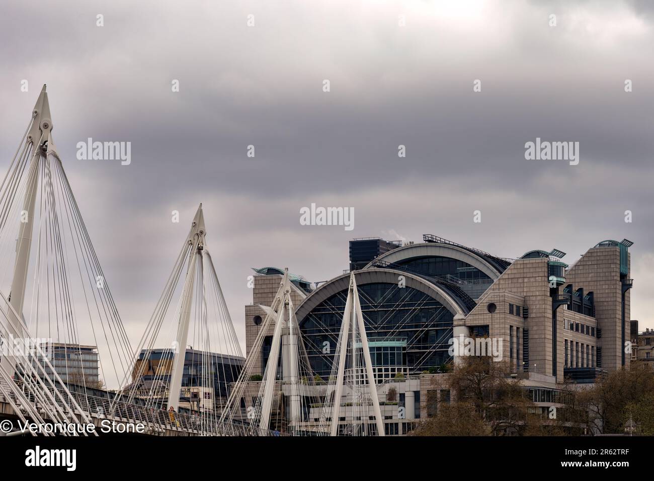 LONDON, ENGLAND - 18. APRIL 2023: Blick auf die Charring Cross Station und die Golden Jubilee Bridge an einem im Frühling bewölkten Nachmittag Stockfoto