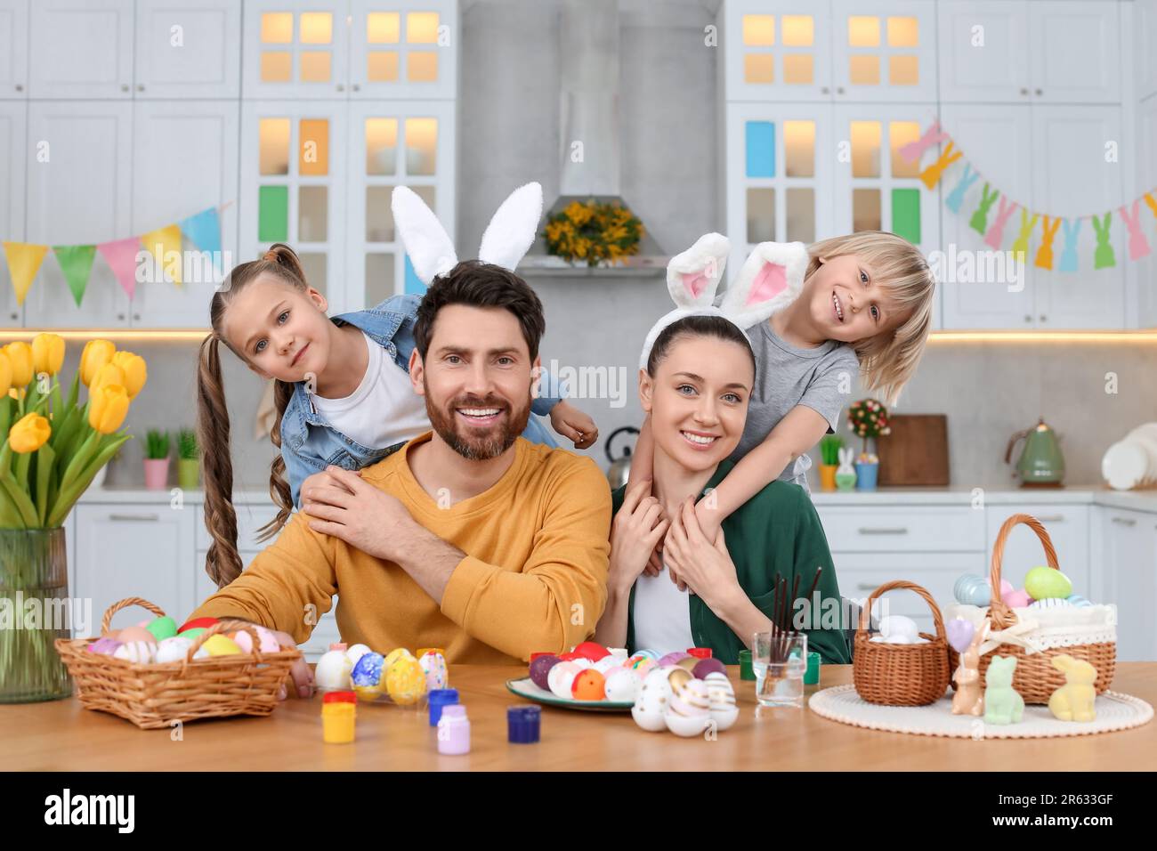 Portrait von glücklicher Familie und Ostereiern am Tisch in der Küche Stockfoto