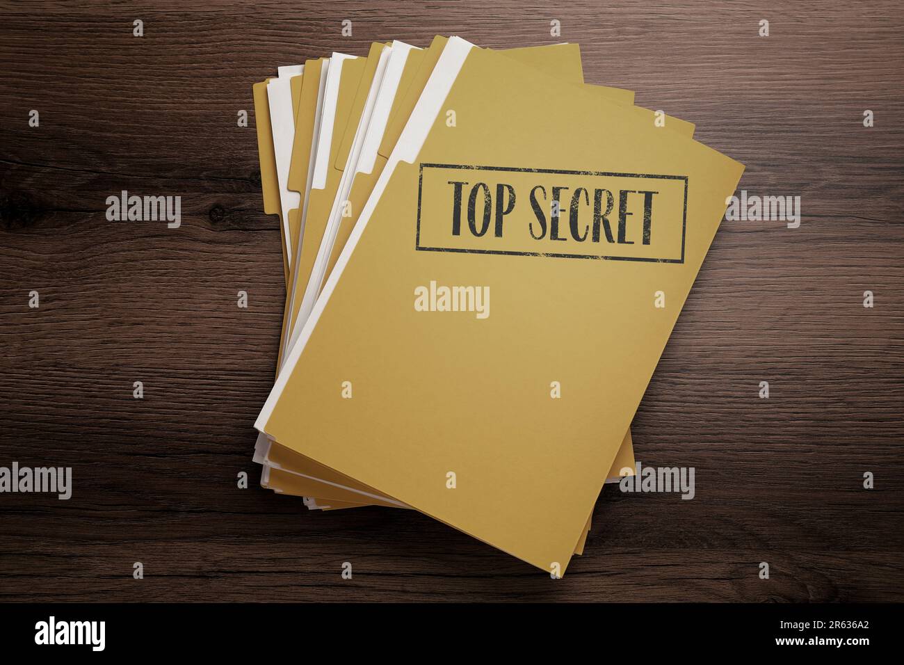 Gelbe Feile mit Dokumenten und Top-Secret-Stempel auf Holztisch, Draufsicht Stockfoto