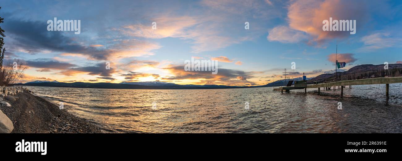 Panoramablick auf das Seeufer im Norden Kanadas im Herbst mit schneebedeckten fernen Bergen und Sonnenuntergangswolken. Panorama beruhigende, friedliche Landschaft Yukon Stockfoto