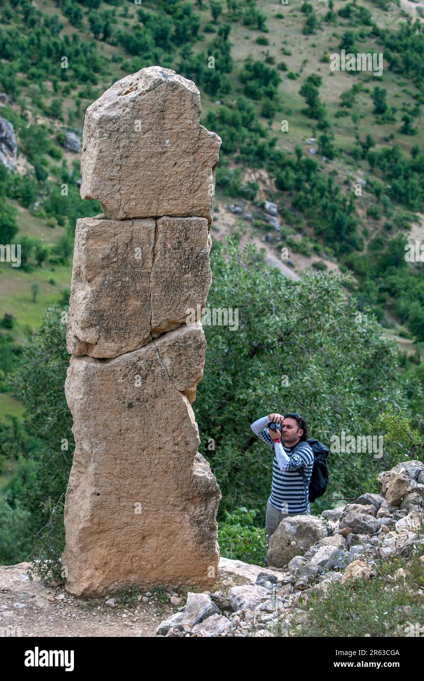 Ein Mann fotografiert das Mithras Relief an den Ruinen von Arsameia (Arsameia auf den Nymphaios) in der Provinz Adiyaman im Südosten Turkiyes. Stockfoto