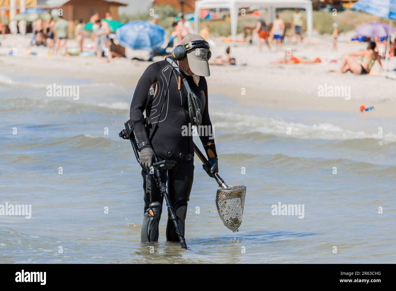 Ukraine, Iron Port - 01. September 2020: Ein Mann mit einem speziellen Gerät und Ausrüstung Metalldetektor auf der Suche nach verlorenen Schmuck und Gold im Meerwasser in der Nähe Stockfoto