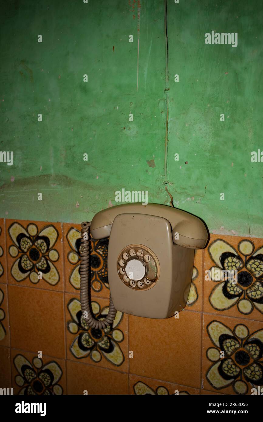 Ein altmodisches Telefon in einer veralteten Küche mit Küchenfliesen und grüner Farbe Stockfoto