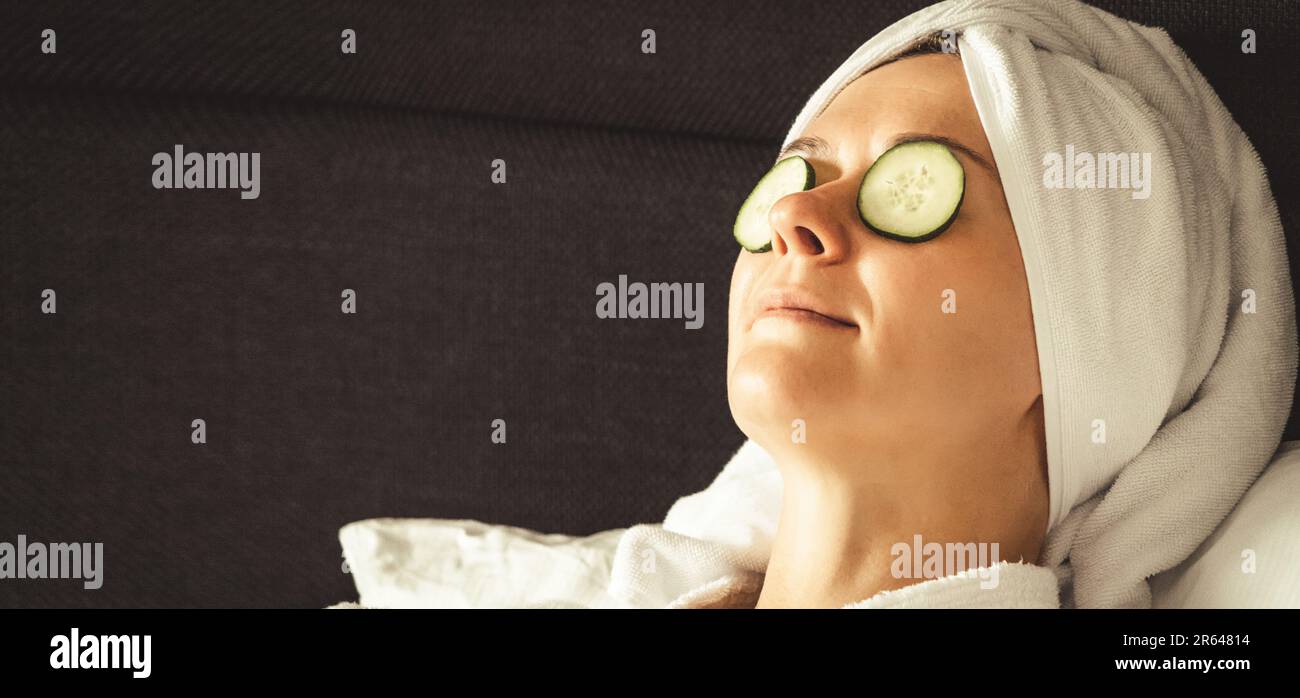 Junge Frau bekommt eine Augenbehandlung mit Gurken im Luxus-Spa-Resort. Wellness- und Heilkonzept. Stockfoto