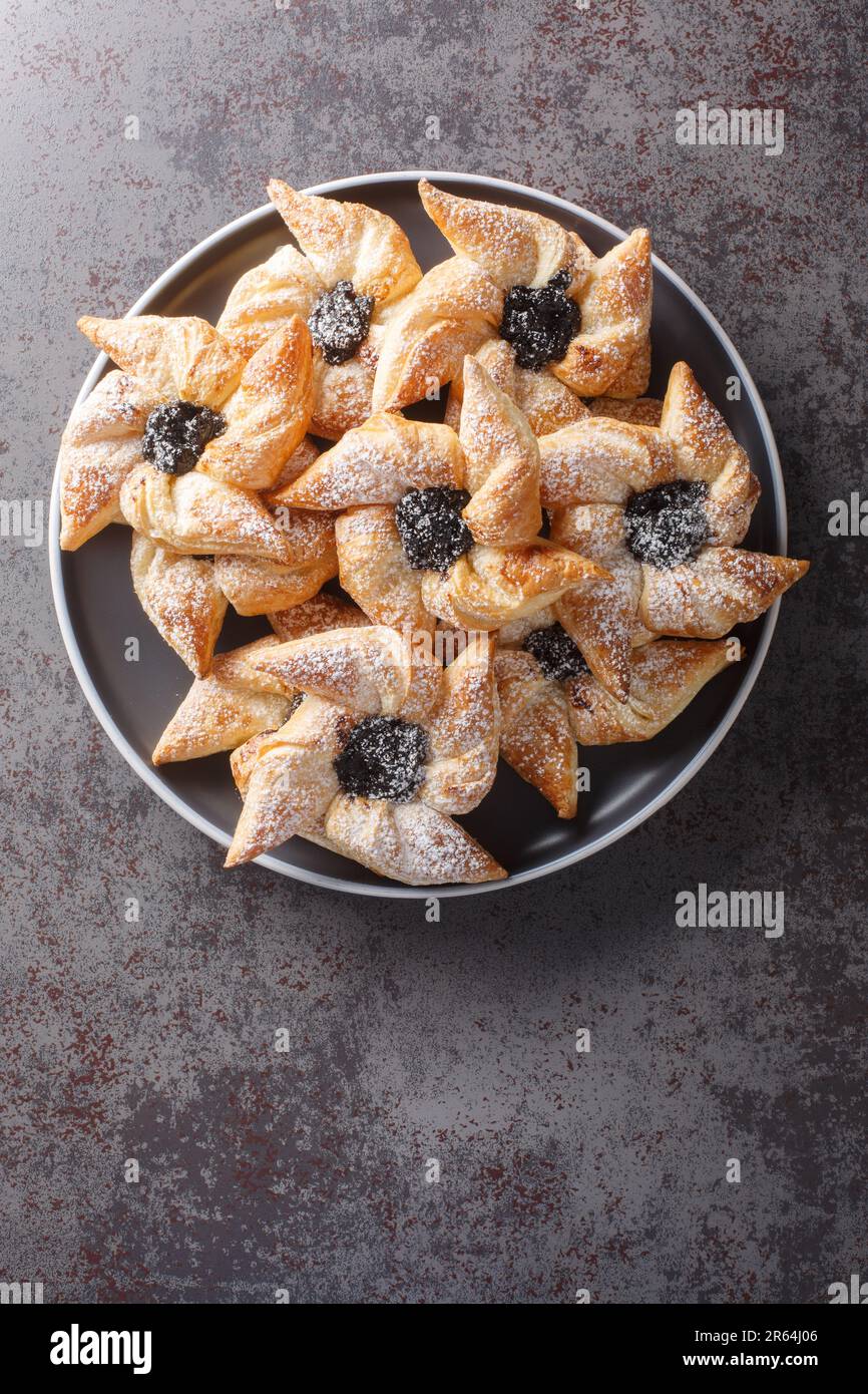 Weicher und lockerer Teig umgibt eine aromatische Marmelade in Joulutorttu,  festliche finnische Weihnachtsstern-Kekse in Nahaufnahme auf einem Teller  auf einem Tisch. Vertikale Draufsicht Stockfotografie - Alamy
