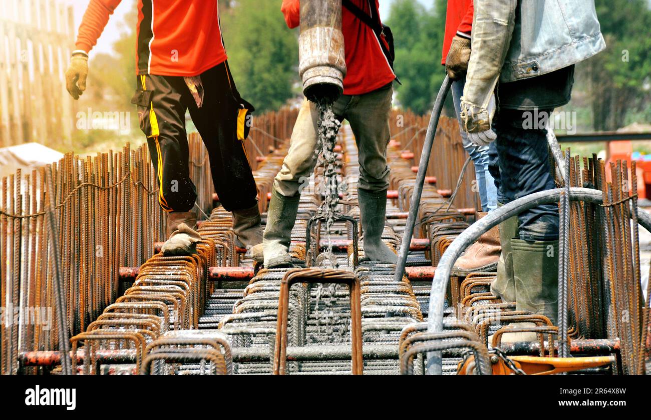 Bauarbeiter, der auf der Baustelle Zement oder Beton mit Pumpenrohr gießt Stockfoto