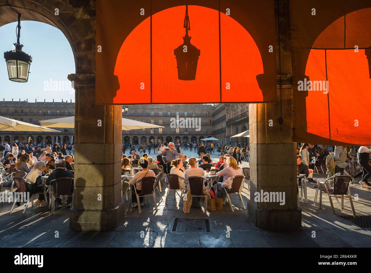 Die Menschen machen im Sommer Spanien, und am späten Nachmittag sehen Sie die Menschen, die sich an Cafétischen auf der barocken Plaza Mayor in der malerischen spanischen Stadt Salamanca entspannen. Stockfoto