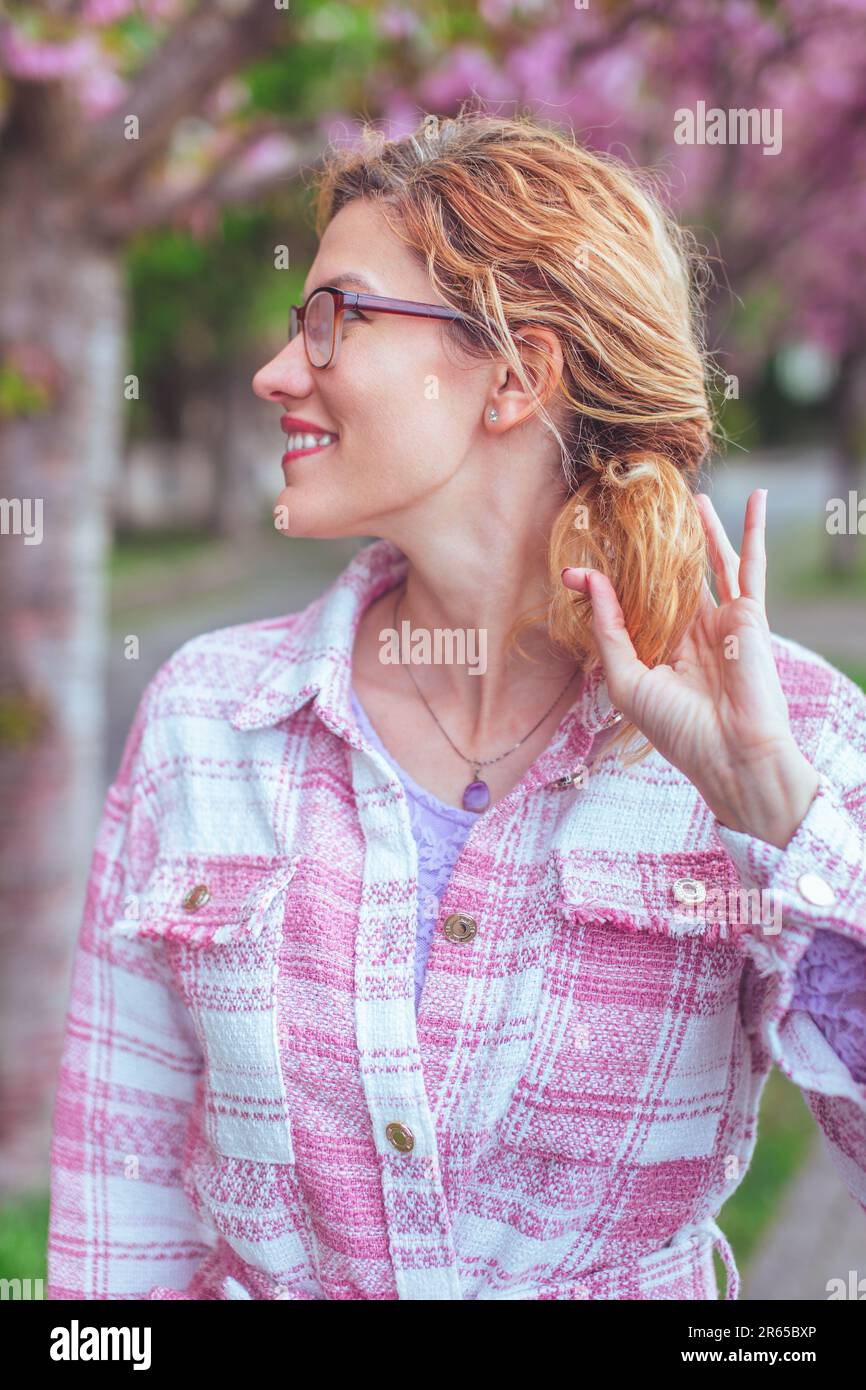 Fröhliche, wunderschöne 30s-jährige Weiße in Brille, die im Park wegschaut Stockfoto