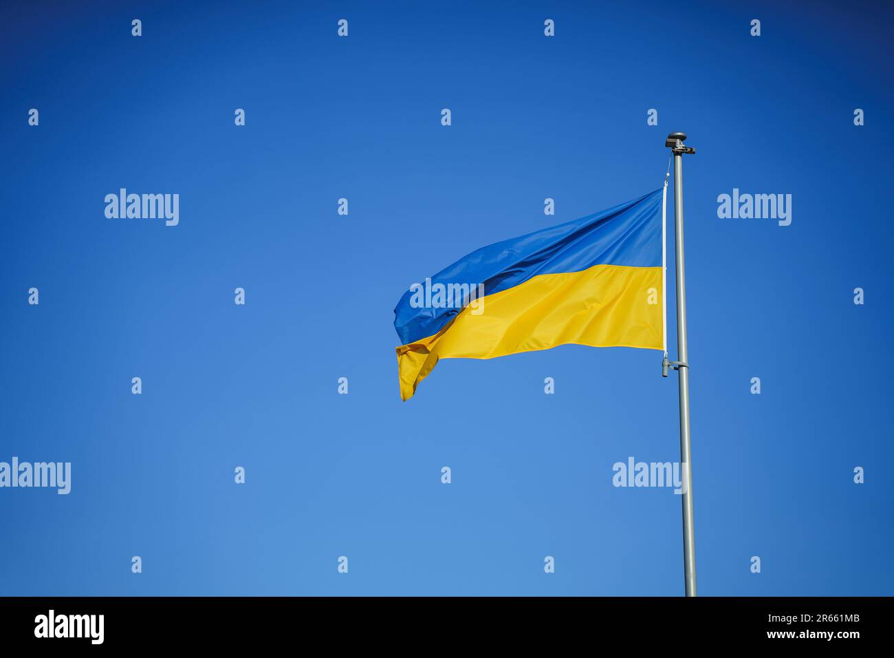 Gelb-blaue Flagge der Ukraine im Wind vor dem Hintergrund eines wolkenlosen Himmels. Stockfoto