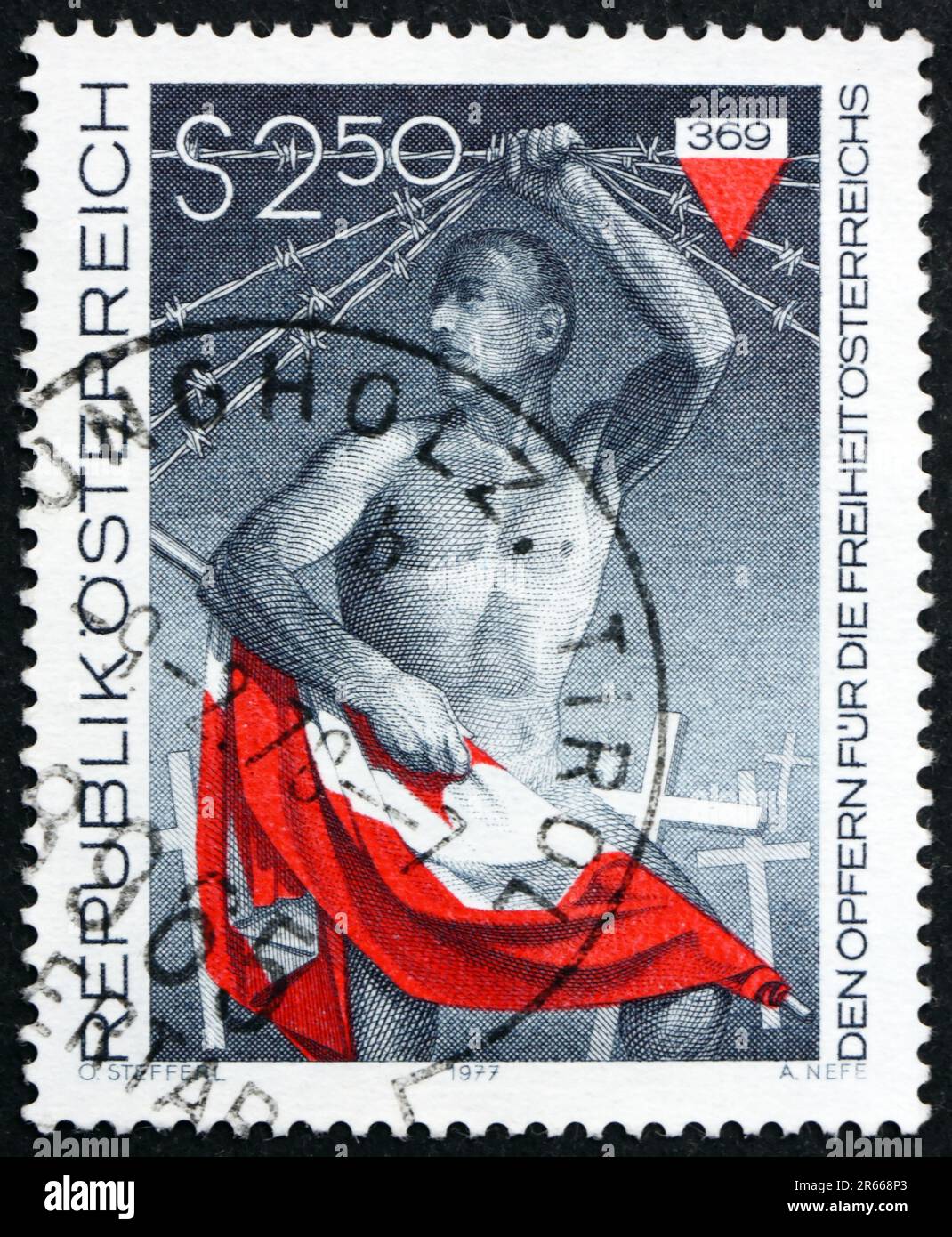 ÖSTERREICH - CA. 1977: Ein in Österreich gedruckter Stempel zeigt den Mann mit österreichischer Flagge, der Stacheldraht hebt, um die Märtyrer für Österreichs Freiheit zu ehren, ca. 1 Stockfoto