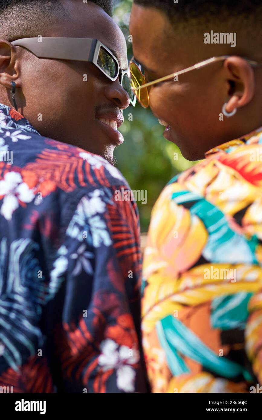Ein junges schwules Paar in Sonnenbrille, das sich küsst Stockfoto