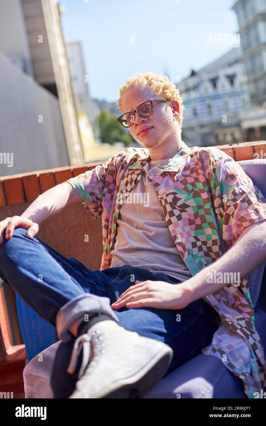 Ein selbstbewusster, cooler junger Albino-Mann auf dem sonnigen Dach Stockfoto