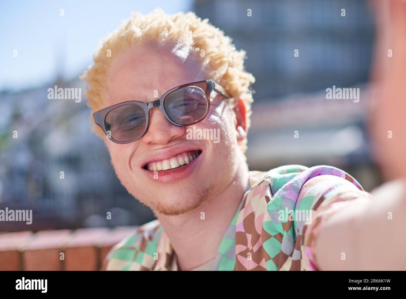 Nahaufnahme Selfie POV Portrait glücklicher junger Albino Mann lächelnd Stockfoto