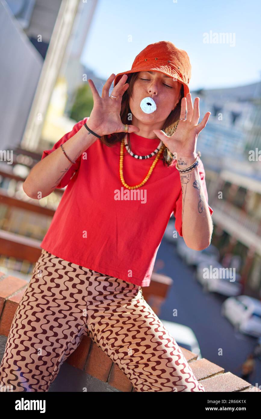 Porträt verspielte junge Frau mit Kaugummi auf dem Dach der Stadt Stockfoto