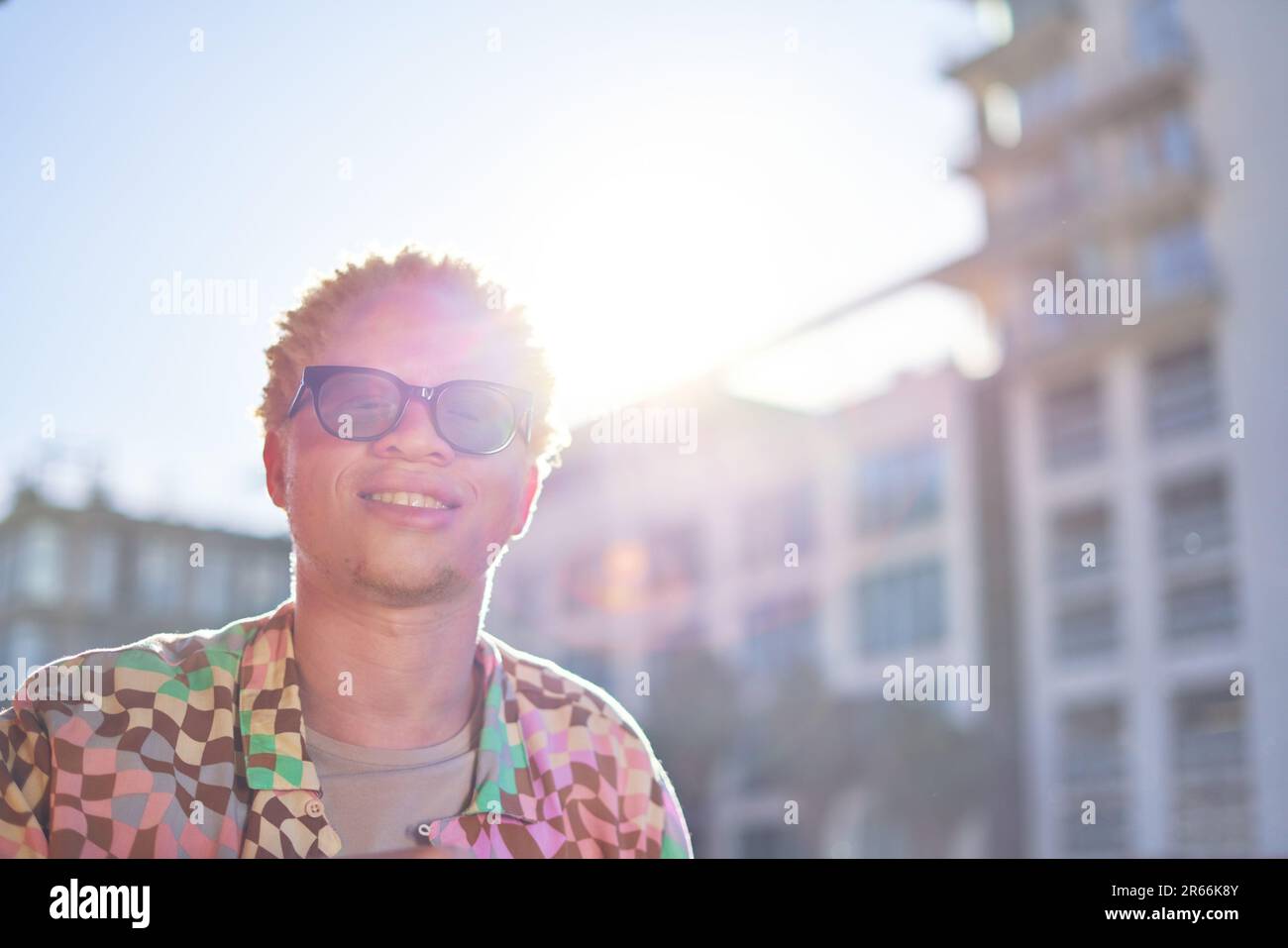 Portrait glücklicher junger Mann in einer sonnigen Stadt Stockfoto