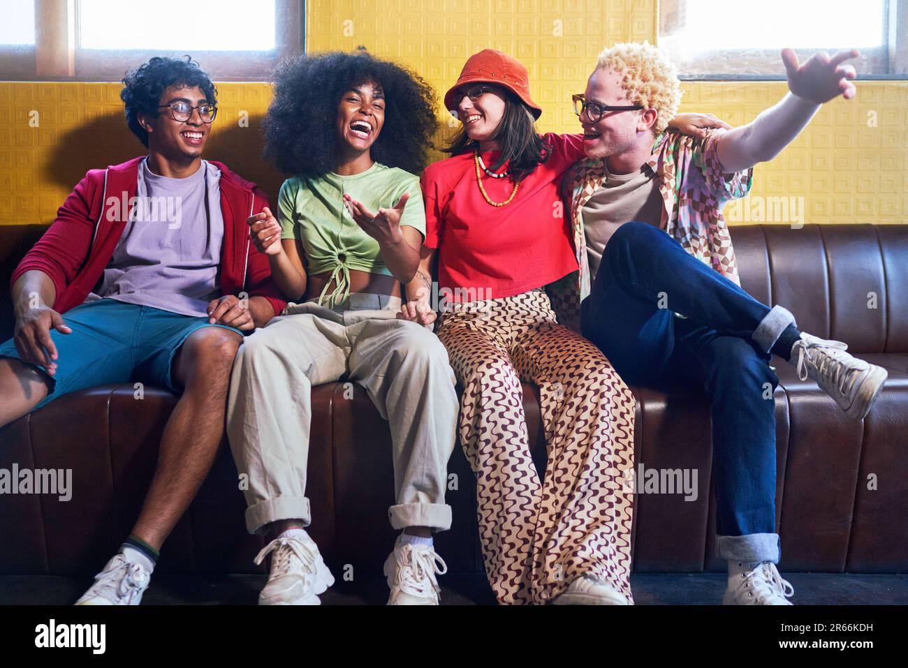 Porträt fröhliche junge Freunde, die auf der Bank lachen Stockfoto