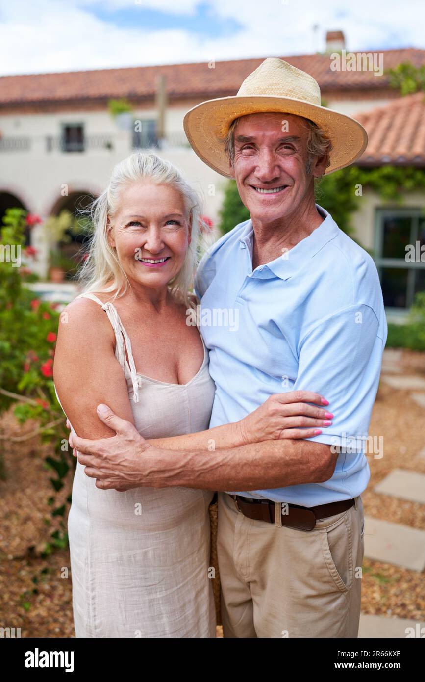 Portrait glückliches Seniorenpaar, das sich im Villengarten umarmt Stockfoto
