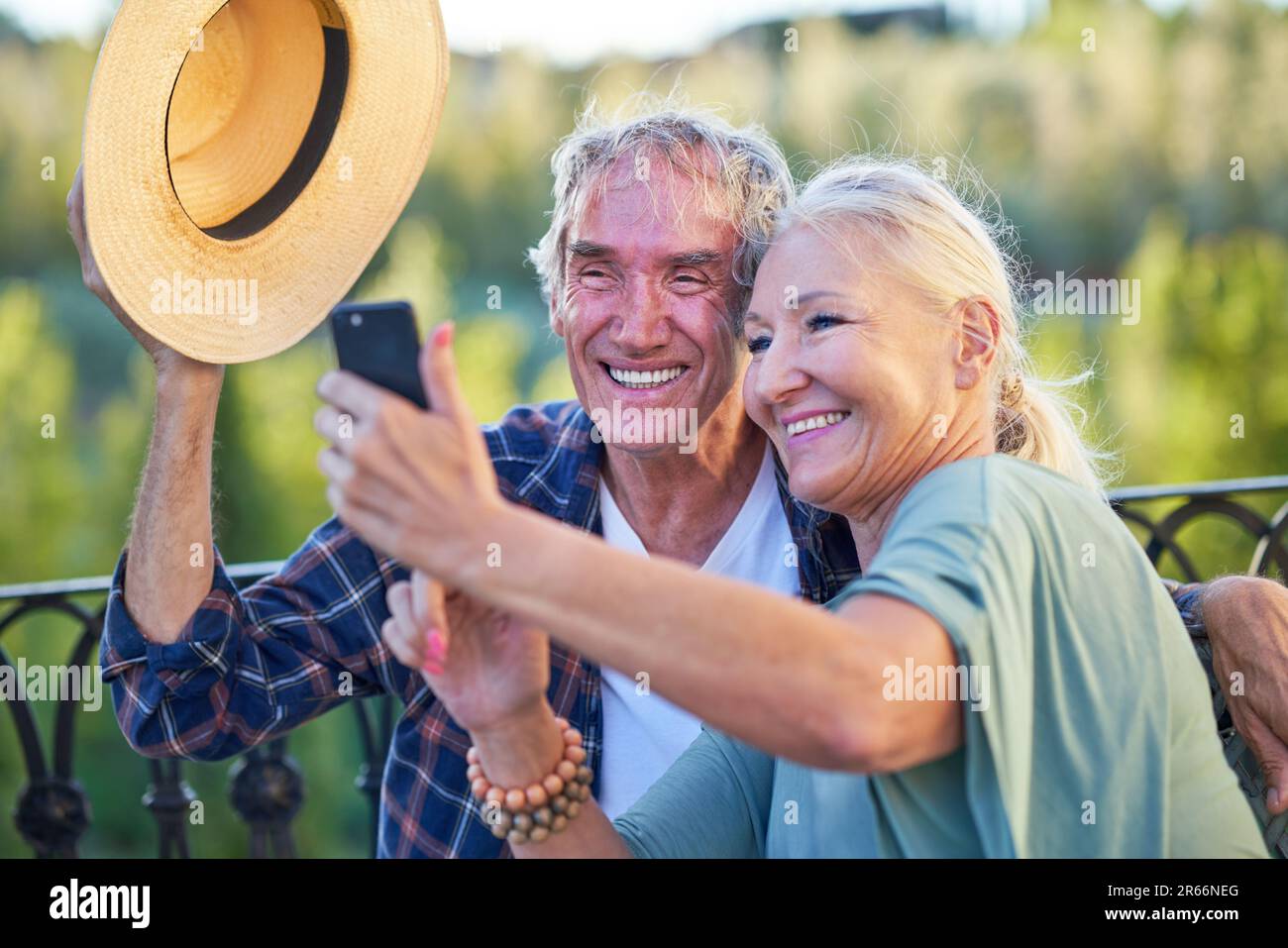 Glückliches Seniorenpaar, das Selfie auf dem Balkon macht Stockfoto