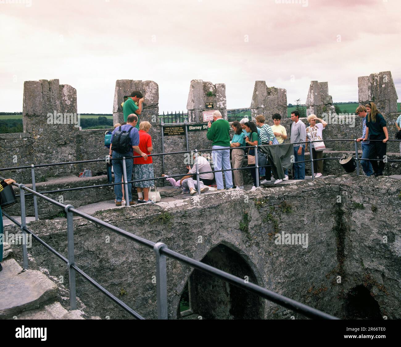 Irland. County Cork. Schloss Blarney. Besucher der Blarney-Steinzeremonie beim Küssen. Stockfoto