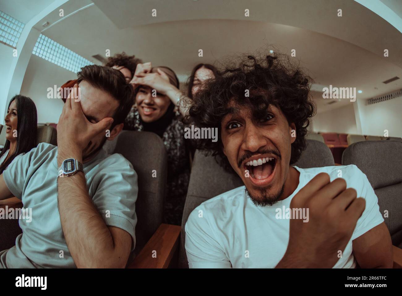 Omedy Film, mit Lächeln in einem Kino eine vielfältige Gruppe von Teenagern versammelt sich, beobachtet ihre Gesichter, genießt das gemeinsame Lachen und die Freude von Stockfoto