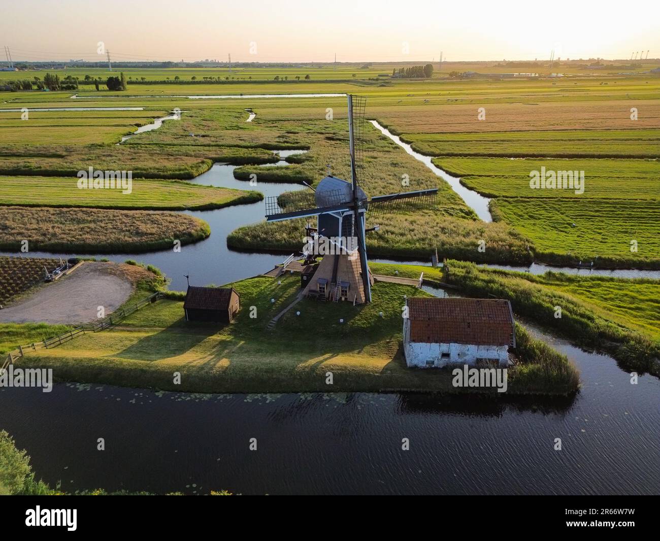 Luftaufnahme in den Abendstunden einer traditionellen holländischen Windmühle, umgeben von Wasser Stockfoto