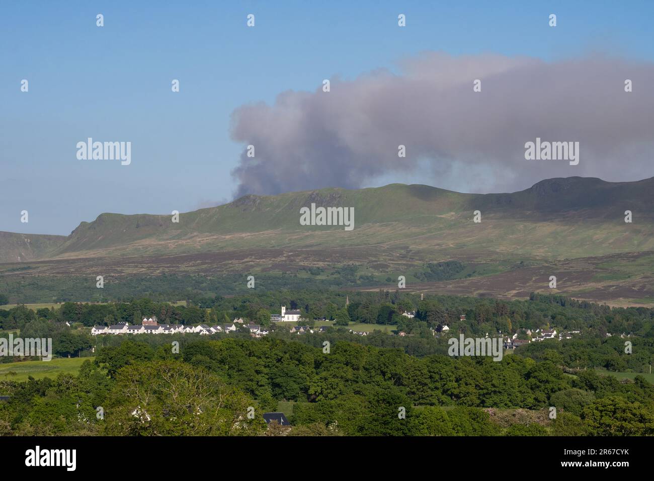 Killearn, Stirling, Schottland, Großbritannien. 7. Juni 2023. Der schottische Feuerwehr- und Rettungsdienst hat eine schottische Warnung vor einem „sehr hohen“ Wildbrandrisiko herausgegeben. Abbildung: Rauchwolken von einem Lauffeuer auf den Campsie Fells, wie sie heute Nachmittag über dem Dorf Killearn zu sehen sind. Scottish Fire and Rescue haben gesagt, dass „aufgrund von Wasserbomben mit dem Hubschrauber, wir empfehlen Anwohnern, die Gegend zu meiden und Fenster und Türen geschlossen zu halten“. Kredit: Kay Roxby/Alamy Live News Stockfoto