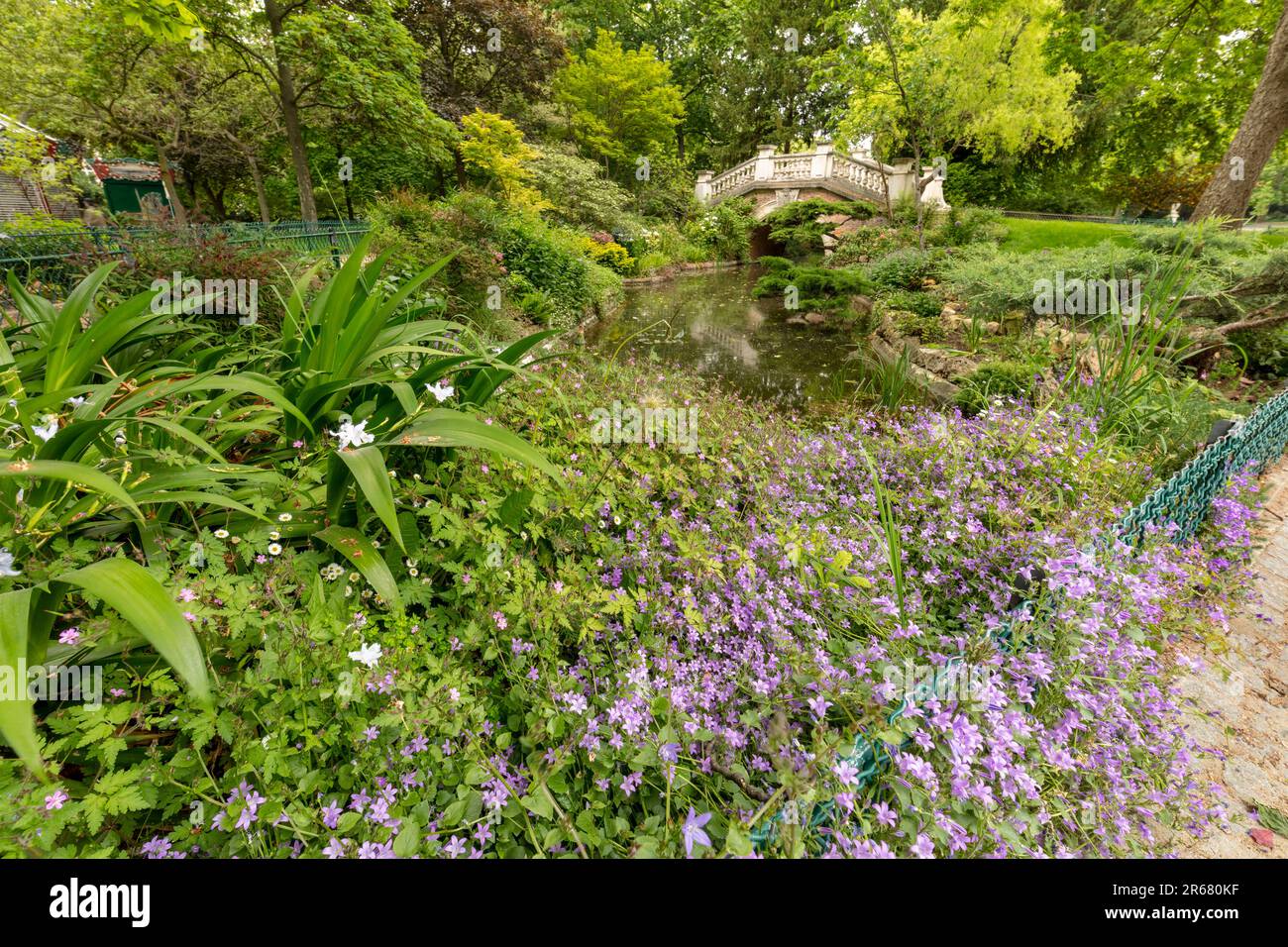 Intimes, hochauflösendes urbanes Landschaftsbild einer romantischen Brücke über den Fluss im Parque Monceau, Paris, Frankreich Stockfoto