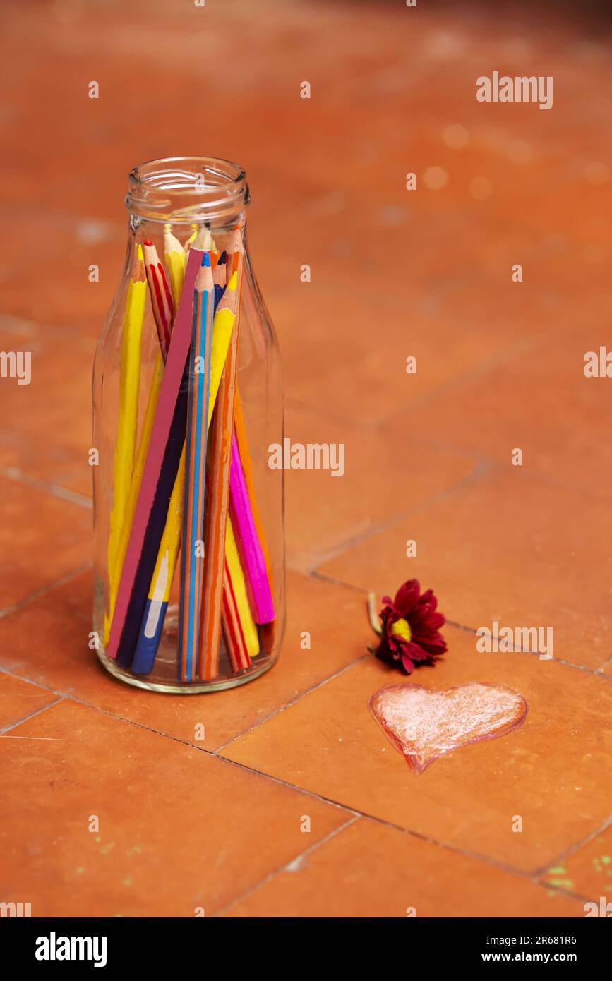 Ein Stillleben mit einer Glasflasche gefüllt mit bunten Bleistiften Stockfoto