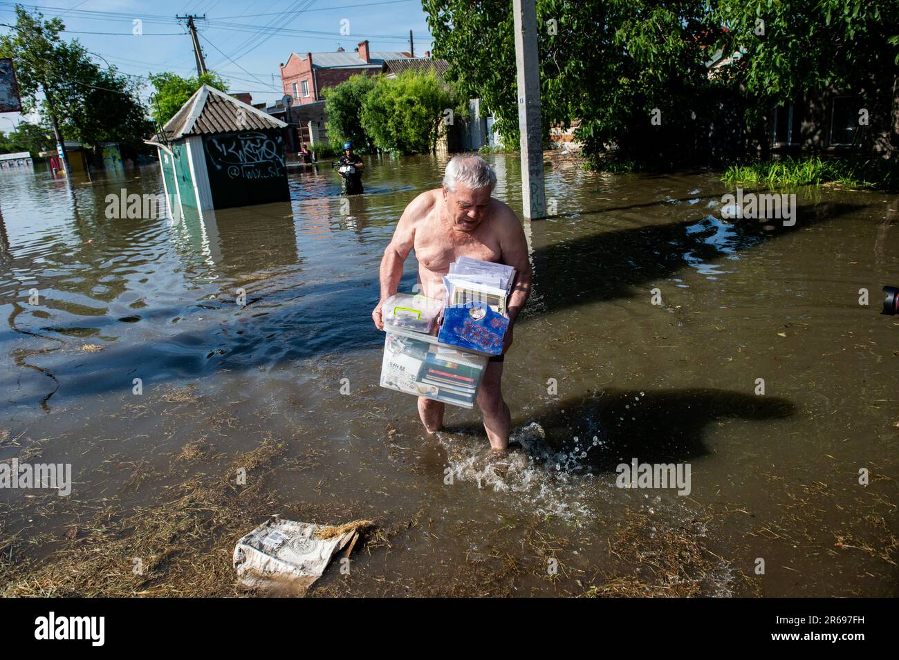 Kherson, Ukraine. 07. Juni 2023. Ein Mann hinterlegt Dokumente und Bilder abseits der Flutgewässer in Kherson, Ukraine, einen Tag nach dem Platzen des Kakhovka-Staudamms entlang des Dnipro Flusses überflutete Gemeinden an beiden Ufern des Flusses südlich des Staudamms. In Dörfern entlang des Dnipro kam es infolge der Zerstörung des Kakhovka-Staudamms zu massiven Überschwemmungen, die die Gemeinden entlang des Flusses im Süden belasten und die Wasserstände für die Gemeinden im Norden gefährlich niedrig fielen. (Foto: Matthew Hatcher/SOPA Images/Sipa USA) Guthaben: SIPA USA/Alamy Live News Stockfoto