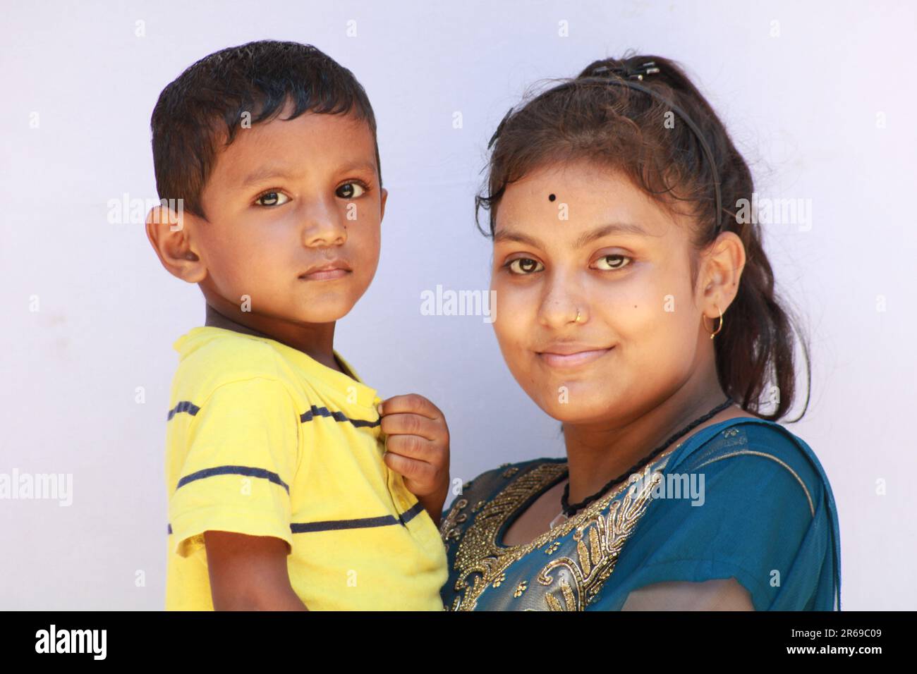 Das indische Mädchen hält einen kleinen Jungen fest Stockfoto