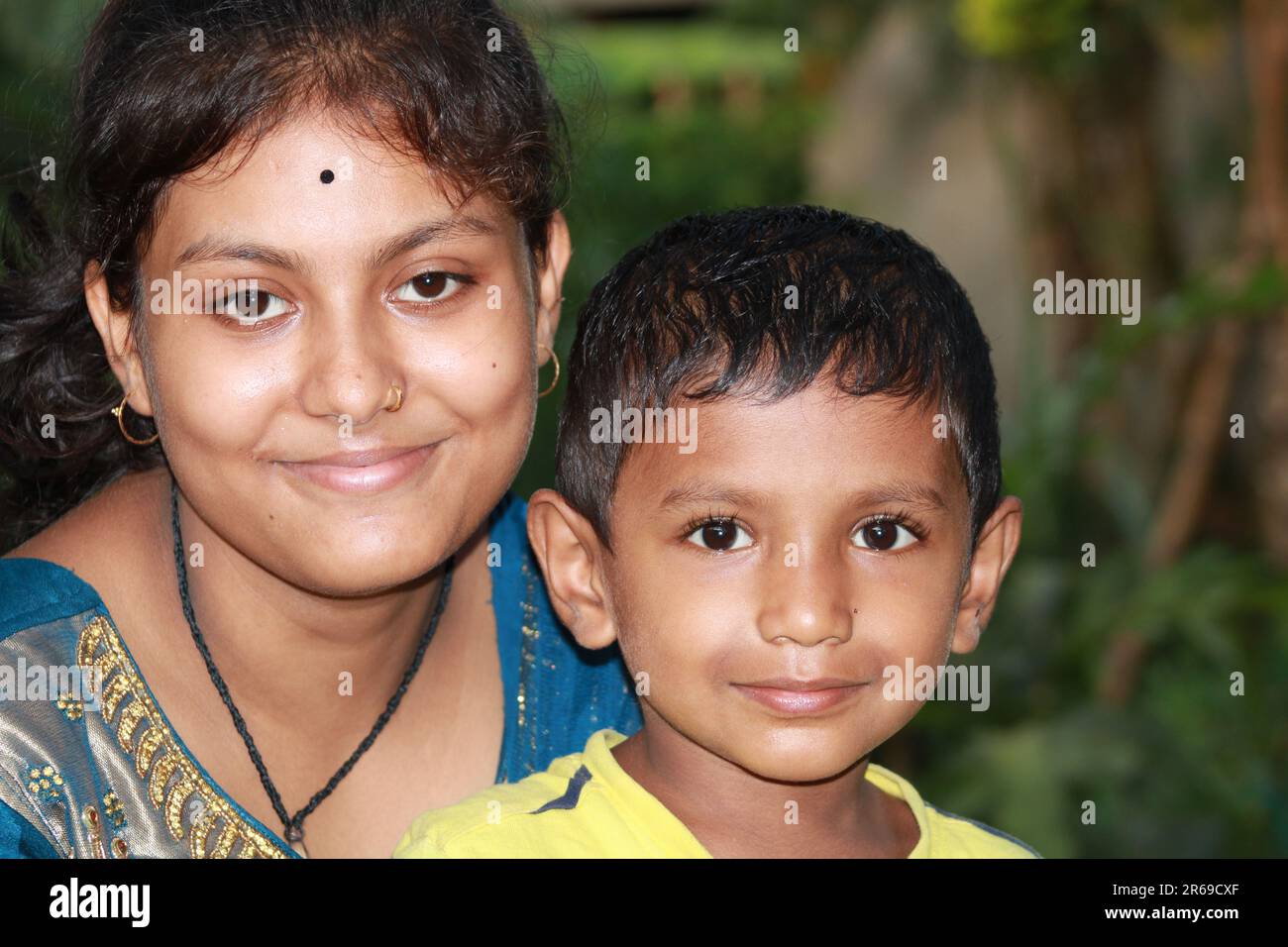 Das indische Mädchen hält einen kleinen Jungen fest Stockfoto