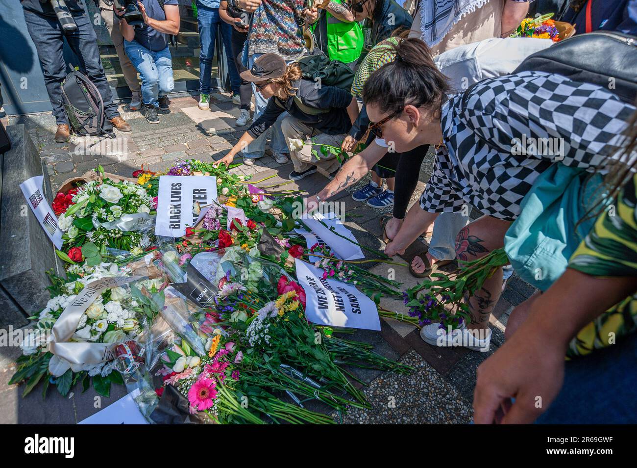 Die Demonstranten platzieren Blumen und Plakate auf den Stufen der belgischen Botschaft, während des Protests von Sanda Dia Black Lives Matter, Kick out Zwart Piet und Extinction Rebellion, unter anderem über hundert Demonstranten, die sich vor der belgischen Botschaft in Den Haag versammelt haben, für Sanda Dia, Ein zwanzig Jahre alter belgischer Farbstudent, der 2018 bei einer Verbindungsinitiationszeremonie namens Reuzegom starb. Die Zeremonie war gleichbedeutend mit Fackeln, an der auch zwei weitere Studenten teilnahmen. Mr. Dia wurde unterworfen: Das Trinken von Fischöl, große Mengen Gin, eine Stunde Verweilen Stockfoto