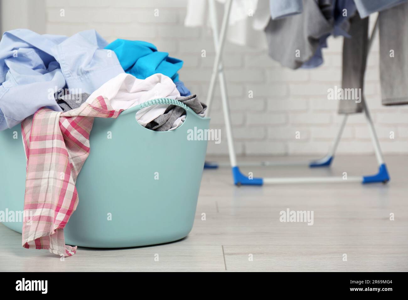 Wäschekorb aus Plastik im Bad mit Kleidung überfüllt. Platz für Text Stockfoto