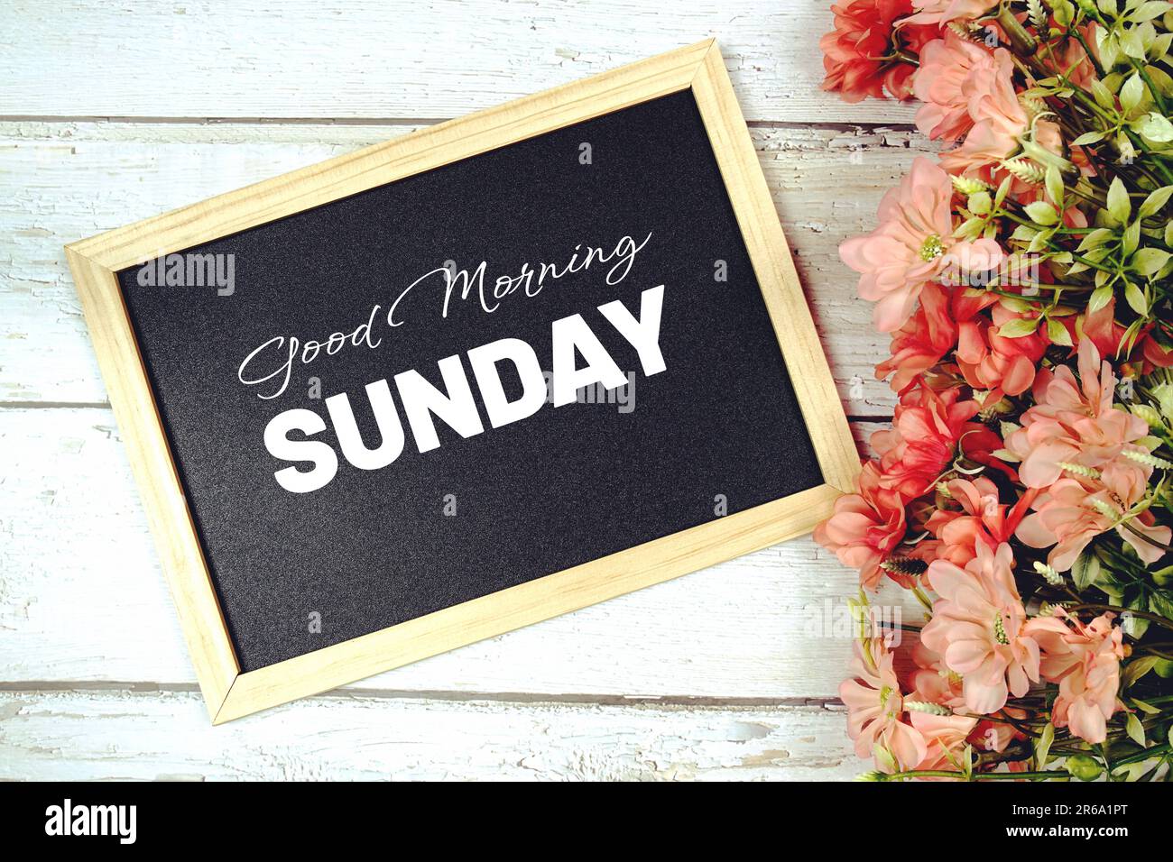 "Guten Morgen Sonntag" Text an der Tafel mit Blumenstrauß Dekoration Stockfoto