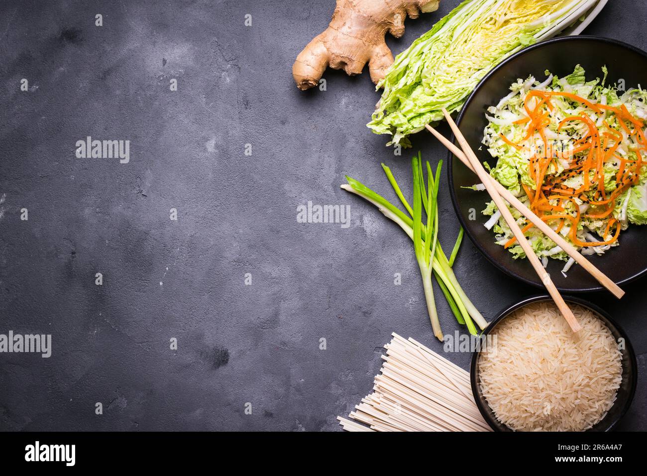 Zutaten für die Zubereitung des chinesischen Abendessens: Weizennudeln, Reis, napakohl, Ingwer, grüne Zwiebeln. Asiatische Kochzutaten. Draufsicht. Vorbereitung gesund Stockfoto