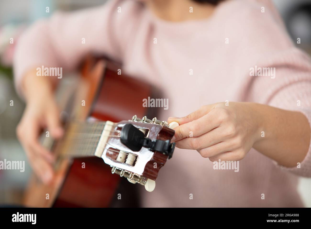 Kunsthandwerker, der eine alte klassische Gitarre repariert und eine Schnur hinzufügt Stockfoto